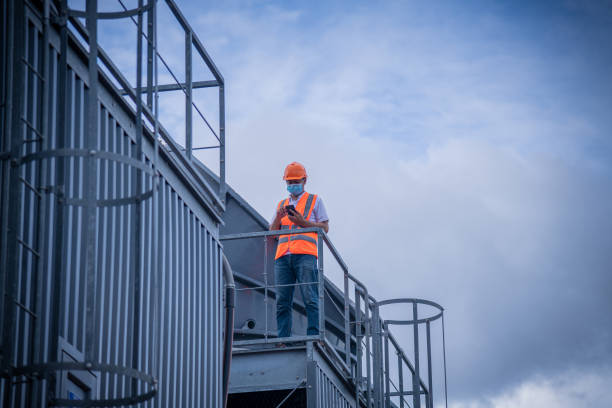 Engineer under checking the industry cooling tower air conditioner is water cooling tower air chiller HVAC of large industrial building to control air system ,wearing mask for protect pollution.