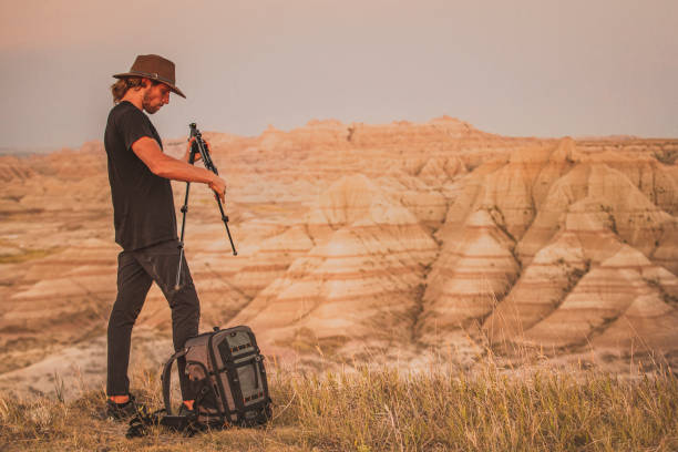 istock Photographer pulling tripod out of backpack in front of vast desert canyons 1329616254