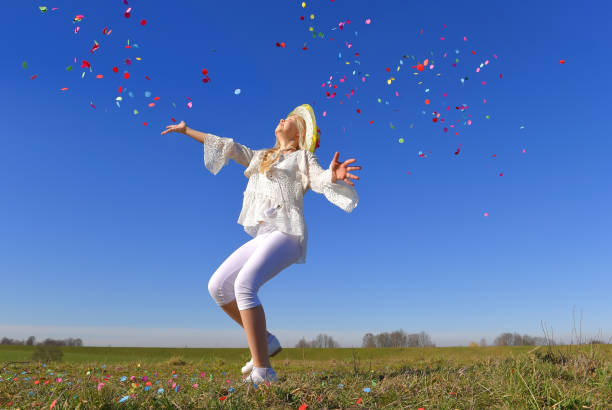 istock White Dressed Girl Throws Confetti In The Air 1329618954