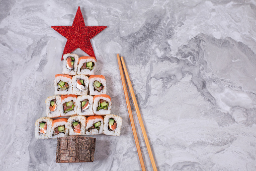Sushi christmas tree with star on stone background, top view with copy space. Christmas or New Year background