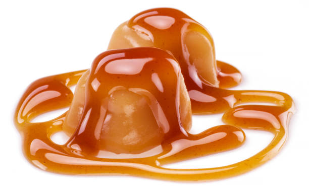 istock Caramel candies covered with melted sugar caramel isolated on white background. 1329621919