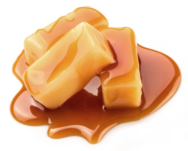 istock Caramel candies covered with melted sugar caramel isolated on white background. 1329621959
