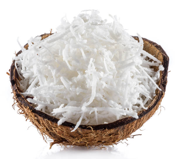 flocos de coco desfiados no pedaço de casca de coco isolados no fundo branco. - coconut flakes - fotografias e filmes do acervo