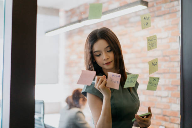 istock Young asian businesswoman writing down ideas on sticky notes 1329622855