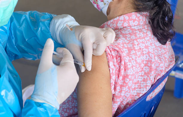 close-up and selective focus of doctor hands who is vaccinating on upper arm of old woman for build immunity infection corona virus or covid-19 in body,  health care and medical - immune defence fotos imagens e fotografias de stock