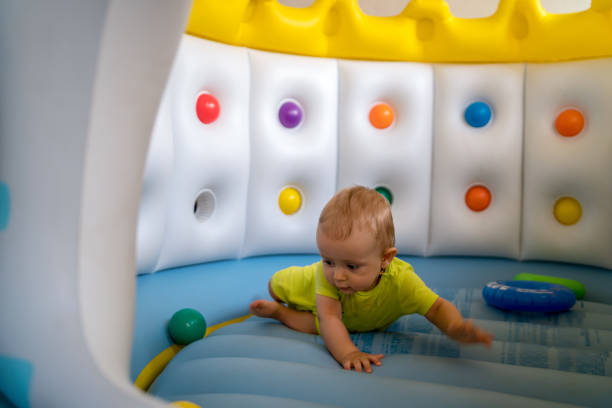istock Child on colorful playground trampoline 1329627449