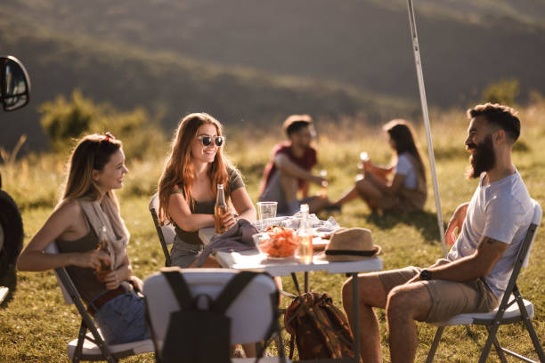 istock Young happy friends talking while spending a spring day on a camping. 1329630490
