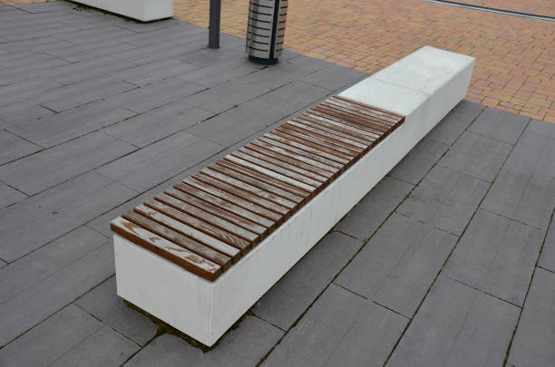 concrete white bench block and wave shape in the park on a dark cobbled square, clean concrete surface gray brown white pedestrian and rest area at the skate park for young people, teenagers