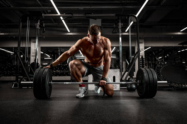 istock Handsome athlete in good shape preparing the barbell for training, achieving success through stubborn and hard training 1329631783
