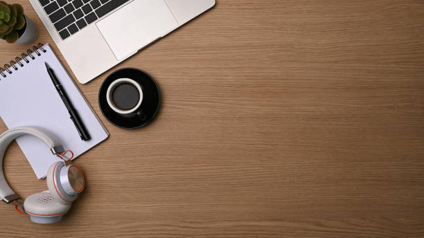 istock Top view coffee cup, headphone, notebook and laptop on wooden desk. 1329631972