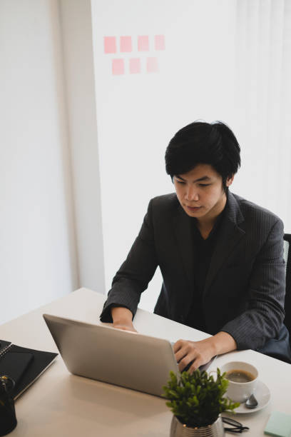 istock Handsome businessman siting in modern office and working with laptop computer. 1329632134
