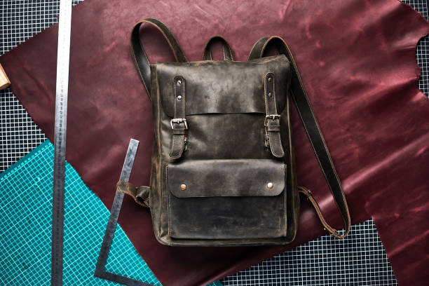 istock Unisex brown leather backpack on a craft background in the workshop on the table, a handmade leather backpack 1329632189