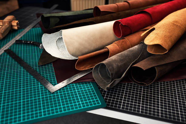 istock Samples of genuine leather of different colors on a craft table, surrounded by tools in a leather dressing and processing workshop 1329632198