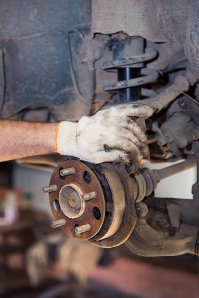 istock A man's gloved hand holds a rusty car wheel hub. I 1329632867