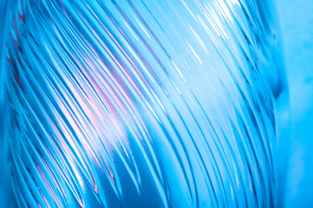 istock Abstract glass background. Texture of wavy glass illuminated with multi-colored light. Pink and blue stains. glass flares. Close up. 1329634460
