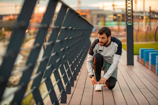 Lacing Up Before Hitting the Road. Man is Preparing for Running over the Bridge.