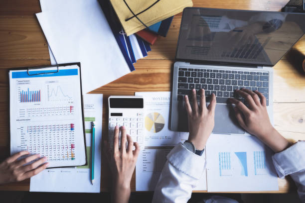 istock focus hand using calculator, Two young business executives are discussing to change their business concept to increase profits and the strength of their business with using calculator  for work. 1329637358