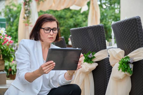 istock Woman professional decorator with digital tablet working outdoors decorating ceremony 1329640190