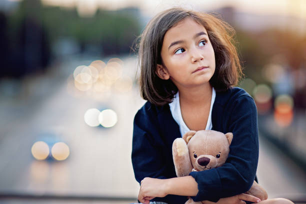 istock Little girl is standing sad on the bridge 1329641048