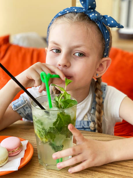 istock Little girl drinking non-alcoholic mojito 1329643018
