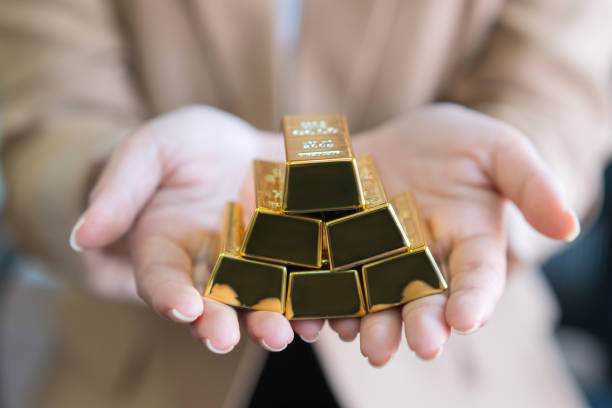 istock woman hands holding gold bars stack as secure investment 1329644048