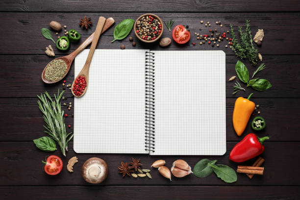 istock Open recipe book and different ingredients on wooden table, flat lay. Space for text 1329649287