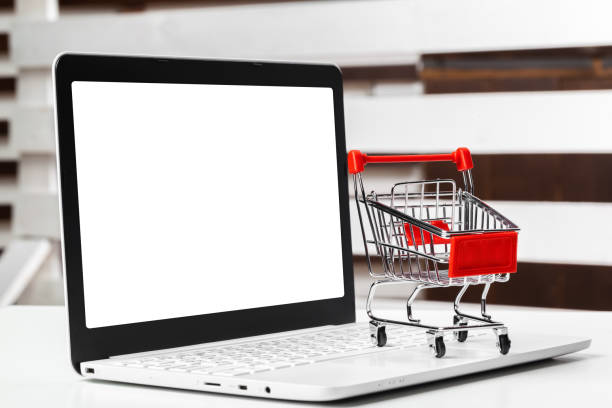 istock shopping online concept. small toy trolley and gadgets on the table 1329649421