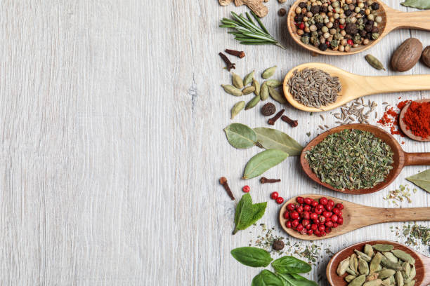 istock Different natural spices and herbs on light wooden table, flat lay. Space for text 1329649721