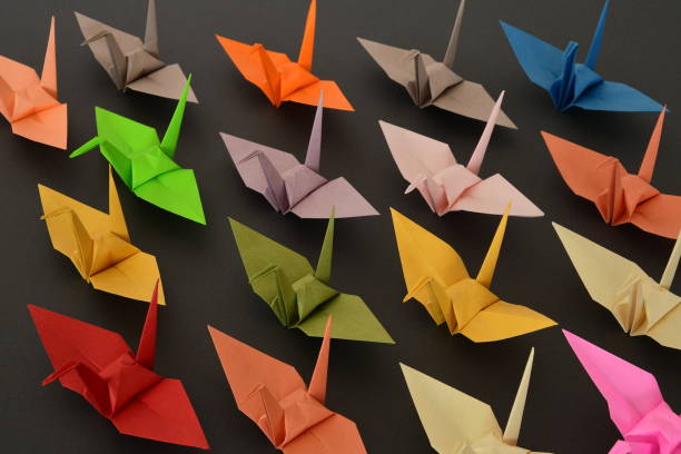 istock Origami paper cranes on black background. 1329651278