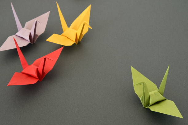 istock Origami paper cranes on black background. 1329651314