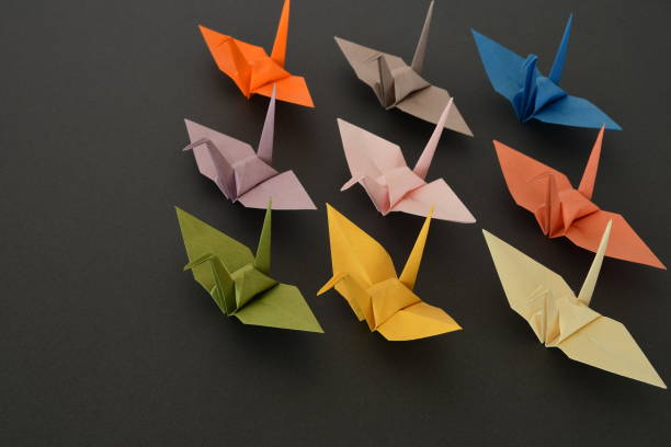 istock Origami paper cranes on black background. 1329651328