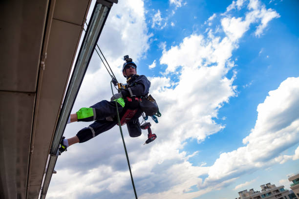 istock Industrial mountaineering worker hangs over residential building 1329652351