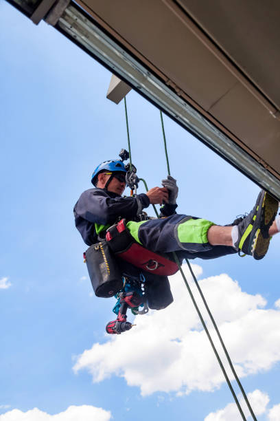istock Industrial mountaineering worker hangs over residential building 1329652388