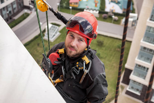 istock Industrial mountaineering worker hangs over residential building 1329652392