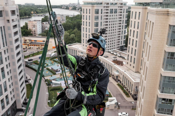 istock Industrial mountaineering worker hangs over residential building 1329652393