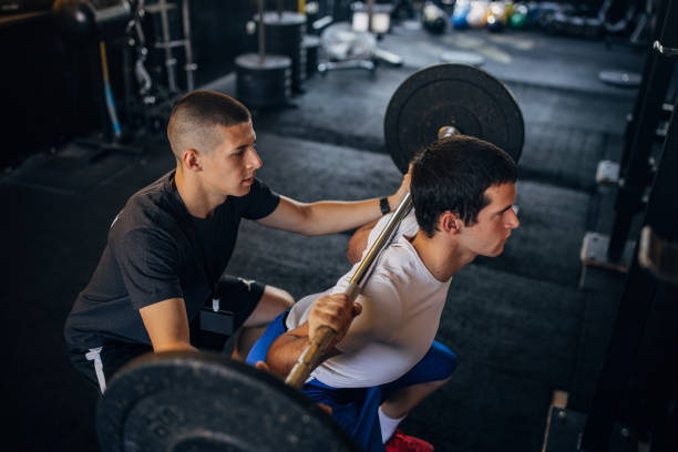 istock Young man exercises with fitness trainer 1329652414