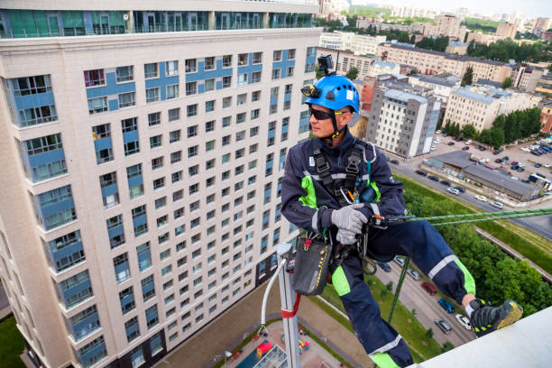 istock Industrial mountaineering worker hangs over residential building 1329652428