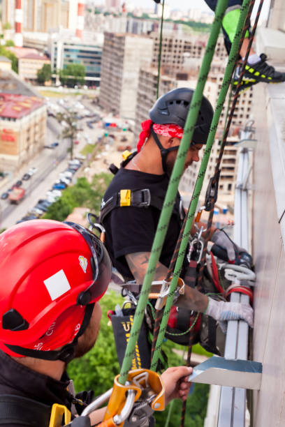 istock Industrial mountaineering worker hangs over residential building 1329652488