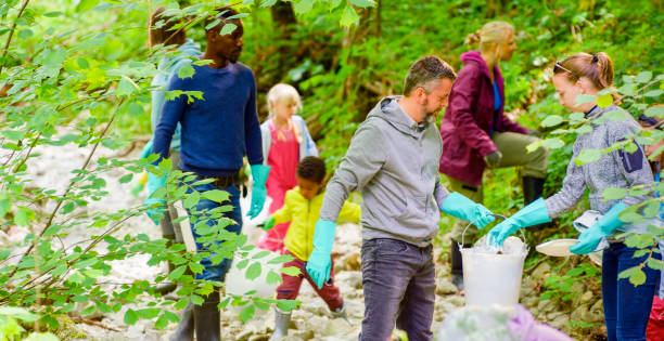 istock Volunteers picking up trash in forest 1329652740