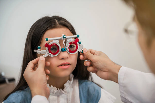 An ophthalmologist testing a young girl's eyes. stock photo
