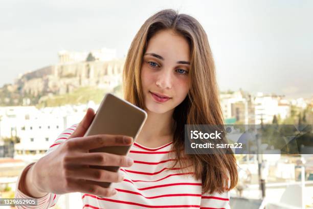 Beautiful Young Woman Makes Selfie On The Background Of A Cityscape Stock Photo - Download Image Now