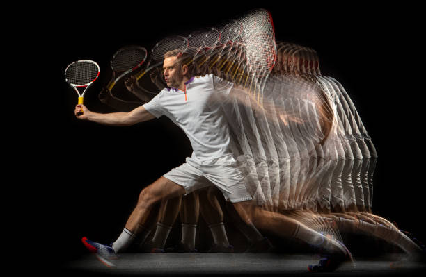 Portrait of young man, male tennis player in motion and action isolated on dark background. Stroboscope effect. Playing tennis. Young man, male badminton player in motion and action isolated on dark background. Stroboscope effect. Concept of healthy lifestyle, professional sport, action, motion, hobby, team. temporal aliasing stock pictures, royalty-free photos & images