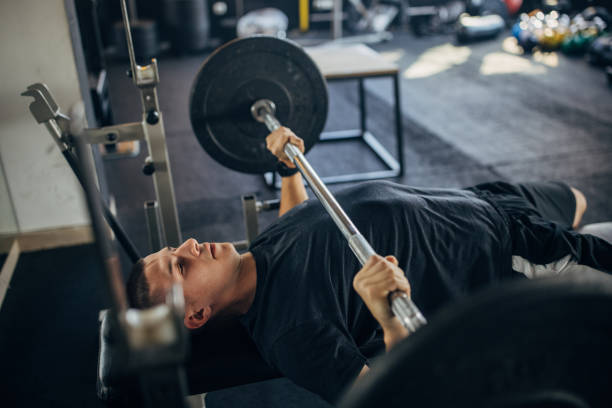 ジムで男のウエイトリフティング - weight bench ストックフォトと画像