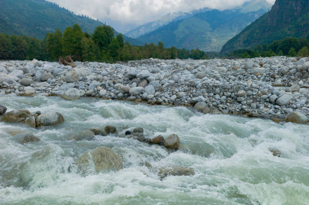 istock River flows through valley flanked by rocks in Manali, India. 1329655842