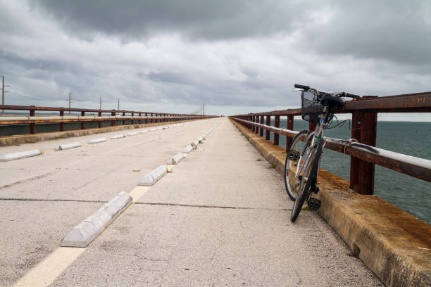 bicycle alone on a long road cycling alone on a long road florida keys biking stock pictures, royalty-free photos & images