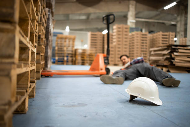 Injury at work. Warehouse worker after an accident in a warehouse. Injury at work. Warehouse worker after an accident in a warehouse. slippery stock pictures, royalty-free photos & images