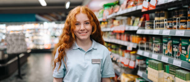 счастливая продавщица в современном супермаркете - part time job sales clerk retail occupation store стоковые фото и изображения