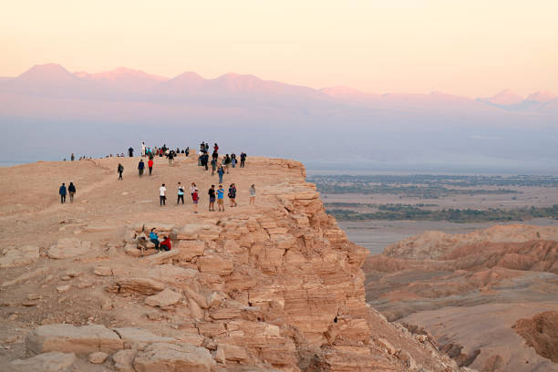 group of visitors on the cliff waiting for the fantastic sunset at valle de la luna or the moon valley in atacama desert, northern chile - san pedro imagens e fotografias de stock