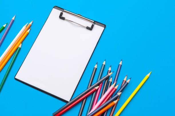 istock Clipboard and office supplies on blue background. Top view. Space for text 1329657978