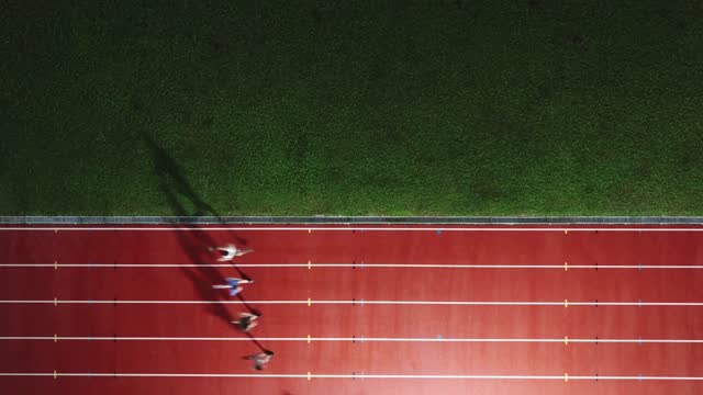 directly above drone point of view asian chinese male athlete running at men's track rainy late evening in stadium